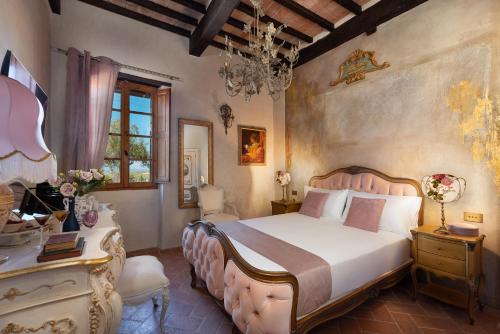 a bedroom with a large bed and a chandelier at Il Miraggio in Val d'Orcia Relais & Spa in San Quirico dʼOrcia