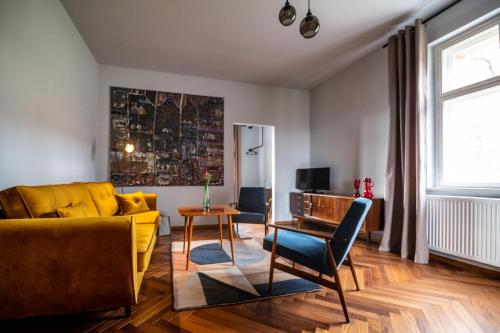 sala de estar con sofá amarillo y mesa en Villa Stara Apteka, en Srebrna Góra