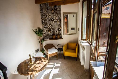 a room with a table and a yellow chair at FONTANE APARTMENTS in Salò