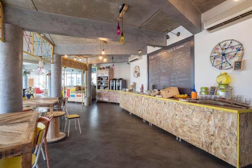 a restaurant with a long counter with tables and chairs at greet Hotel Bordeaux Aeroport in Mérignac