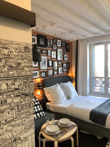 a bedroom with a bed and a wall with pictures at Résidence Labyrinthe in Paris