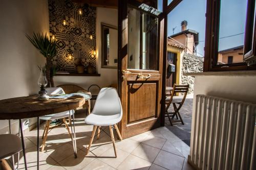 a patio with a table and chairs and a wooden door at FONTANE APARTMENTS in Salò