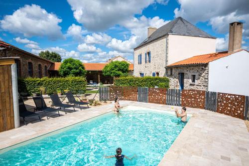 un groupe d'enfants jouant dans une piscine dans l'établissement Le DOMAINE DES ECOLIERS B&B, à Montaigu-Vendée