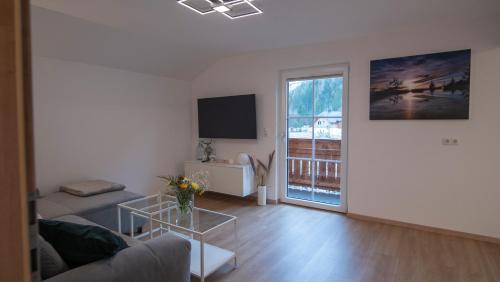 a living room with a couch and a tv at DAS JOHANN Apartments im Ausseerland in Bad Aussee