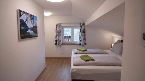 a bedroom with two beds and a window at DAS JOHANN Apartments im Ausseerland in Bad Aussee