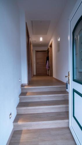 a hallway with stairs with a person walking down it at DAS JOHANN Apartments im Ausseerland in Bad Aussee