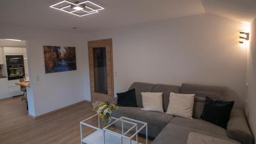 a living room with a couch and a table at DAS JOHANN Apartments im Ausseerland in Bad Aussee