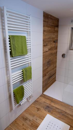a bathroom with a shower with green towels at DAS JOHANN Apartments im Ausseerland in Bad Aussee