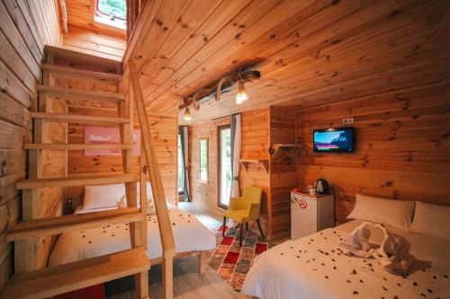 ein Schlafzimmer mit einer Treppe in einem Blockhaus in der Unterkunft Efulim Apart in Çamlıhemşin