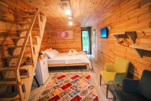 a room with a bed and a staircase in a log cabin at Efulim Apart in Çamlıhemşin