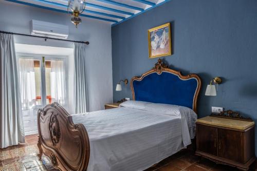 ein blaues Schlafzimmer mit einem Bett und einer blauen Wand in der Unterkunft LA CASA DE JULIA in Almagro