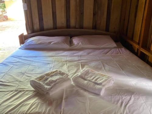 a bed with white sheets and two pillows on it at Finca Avellanas in Playa Avellana