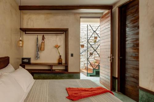 a room with a bed, a rug and a painting on the wall at Hotel Mamazul Tulum in Tulum