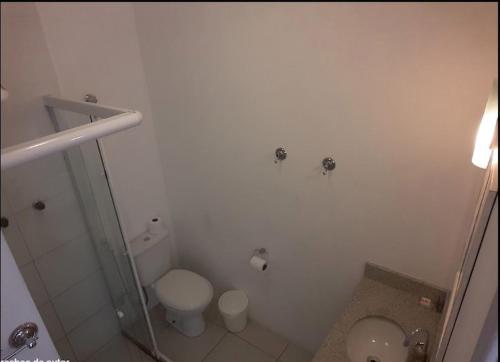 uma casa de banho branca com um WC e um chuveiro em Lulu Pousada Buzios em Búzios