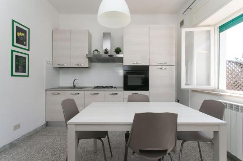 a white kitchen with a white table and chairs at N050 - Numana, trilocale in centro con portico e posto auto in Numana