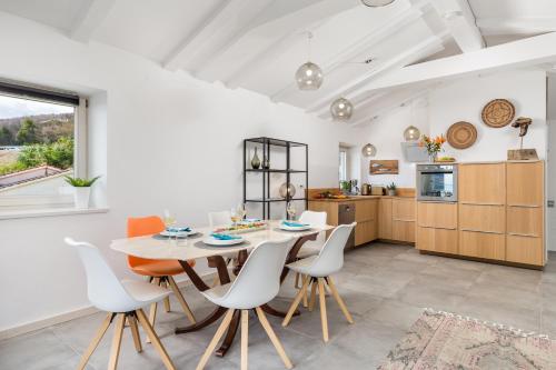 uma cozinha e sala de jantar com mesa e cadeiras em Pogled the View em Opatija