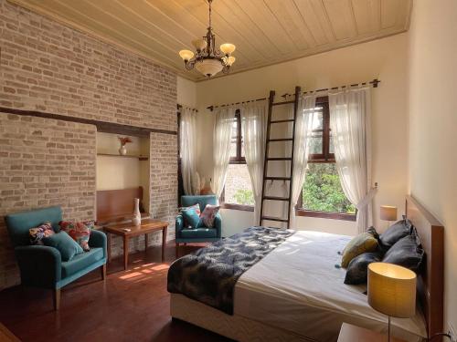 a bedroom with a bed and two blue chairs at Hotel Mille Kaleiçi in Antalya