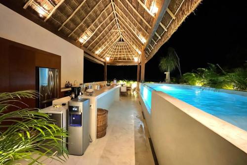 an outdoor bar with a swimming pool at night at Villa 240m2 - 16 persons - 6 rooms - 2 swimming Pool - 3 Jacuzzis in Tulum