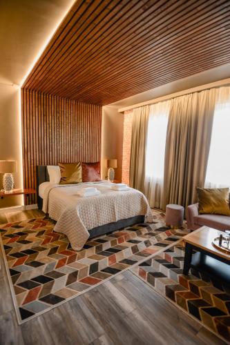 a bedroom with a large bed and a couch at Bahnhofs hotel in Alūksne
