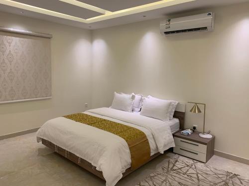 a bedroom with a large bed and a air conditioner at Luxury fully furnished villa ڤيلا مؤثثة in AlUla