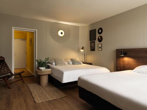 a hotel room with two beds and a chair at Townhouse Apartments Maastricht in Maastricht