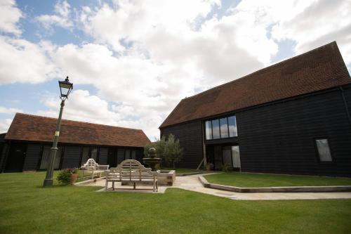 a building with benches and a street light in the grass at Channels Retreat in Chelmsford