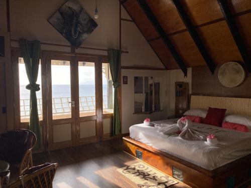 a bedroom with a bed with a view of the ocean at Mouggae Blues Villas in Beau Vallon