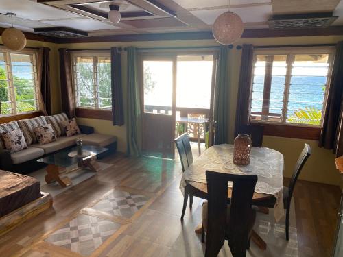 a living room with a table and a couch at Mouggae Blues Villas in Beau Vallon