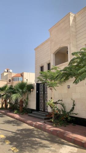 a building with a door and palm trees in front of it at Luxury fully furnished villa ڤيلا مؤثثة in AlUla