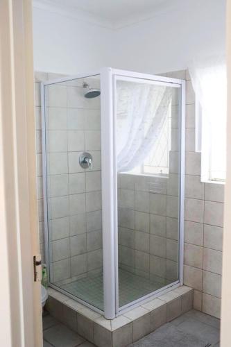 a shower with a glass door in a bathroom at The Nook in Cradock