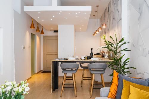 a kitchen with a large island with stools at Ivory Apartment by LoftAffair in Krakow
