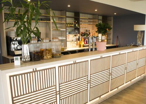 un bar dans un restaurant avec des plantes au comptoir dans l'établissement Logis Hôtel Le Bretagne, au Vivier-sur-Mer