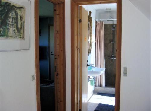 a bathroom with a sink and a toilet and a mirror at Feriegården i Floutrup in Roslev