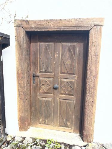 an old wooden door in the side of a building at Jurahaus Hirschberg EG Wohnung in Beilngries