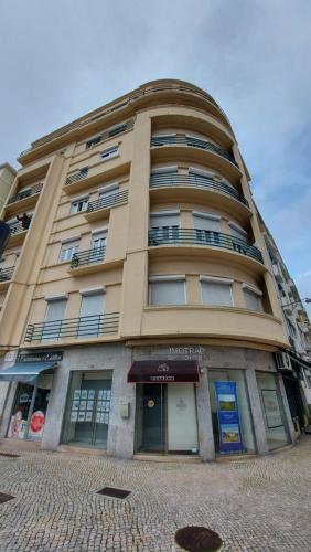 a tall tan building with windows and a storefront at Green View Home in Lisbon