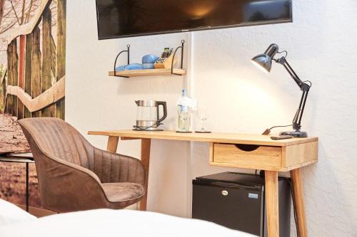 a desk with a lamp and a chair in a room at Zum Fischer am See ***S in Prien am Chiemsee
