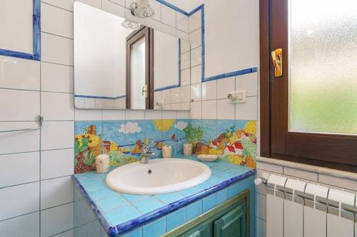 ein Bad mit einem Waschbecken und einem Spiegel in der Unterkunft Villa dei Mori in Scopello