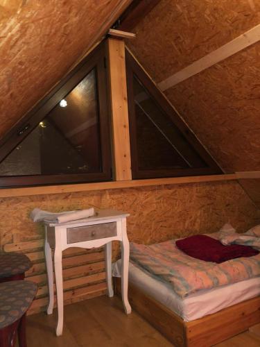 a room with a bed and a table in a cabin at Rodzinny Domek Apartament in Wisłoczek