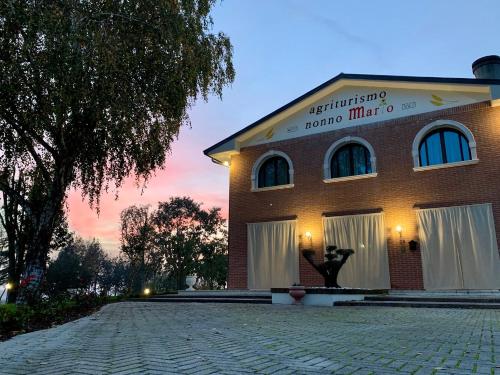 a brick building with a sign on the side of it at Agriturismo Nonno Mario in Fossone dʼAdige