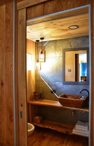 a bathroom with a wooden sink and a mirror at Căsuța de sub cireș in Piatra Neamţ
