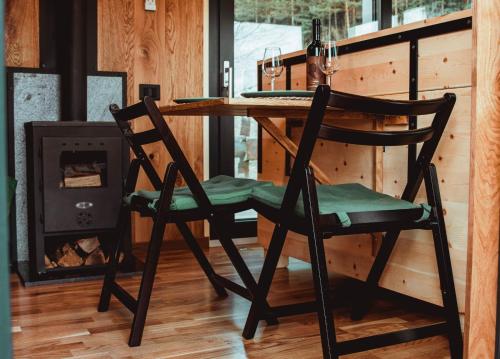 a wooden chair sitting at a table with a fireplace at Căsuța de sub cireș in Piatra Neamţ