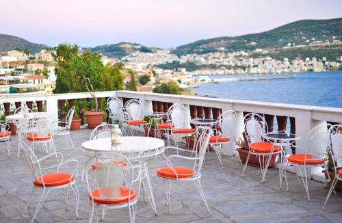 um grupo de mesas e cadeiras numa varanda em Mirini Hotel em Samos