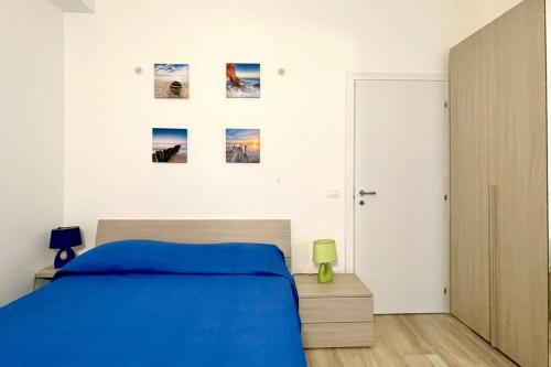 Viva Vista Mare Trilo PianoTerra في بورتو سيساريو: غرفة نوم بسرير ازرق وصور على الحائط