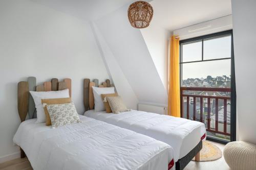 deux lits dans une chambre avec balcon dans l'établissement Séjour pour 6 face à la grande plage de Pléneuf, à Pléneuf-Val-André