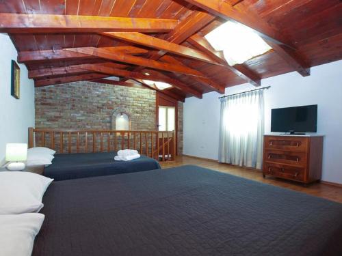 a bedroom with two beds and a flat screen tv at Apartmani Dorma in Vidulini