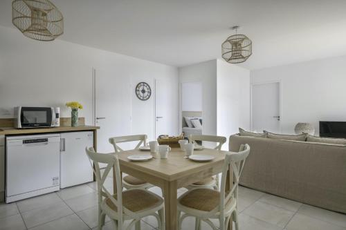 une cuisine et une salle à manger avec une table et des chaises dans l'établissement Face à la mer, bel appartement pour 6, à Pléneuf-Val-André