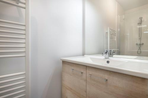 une salle de bain avec un lavabo blanc et un miroir dans l'établissement Appartement pour 6, plage de Pléneuf Val André, à Pléneuf-Val-André