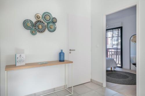 プレヌフ・ヴァル・アンドレにある50m de la plage, bel appartement pour 4のテーブルと皿が壁に掛けられた部屋