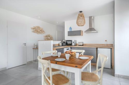 une cuisine avec une table et des chaises en bois dans l'établissement Bel appartement pour 4 à 50m de la plage, à Pléneuf-Val-André