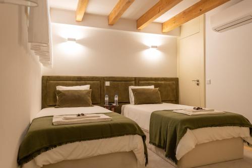 a bedroom with two beds with green and white sheets at CC Downtown Palace - D in Porto